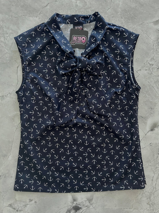 a flat lay of bow top with tossed white anchors on navy background