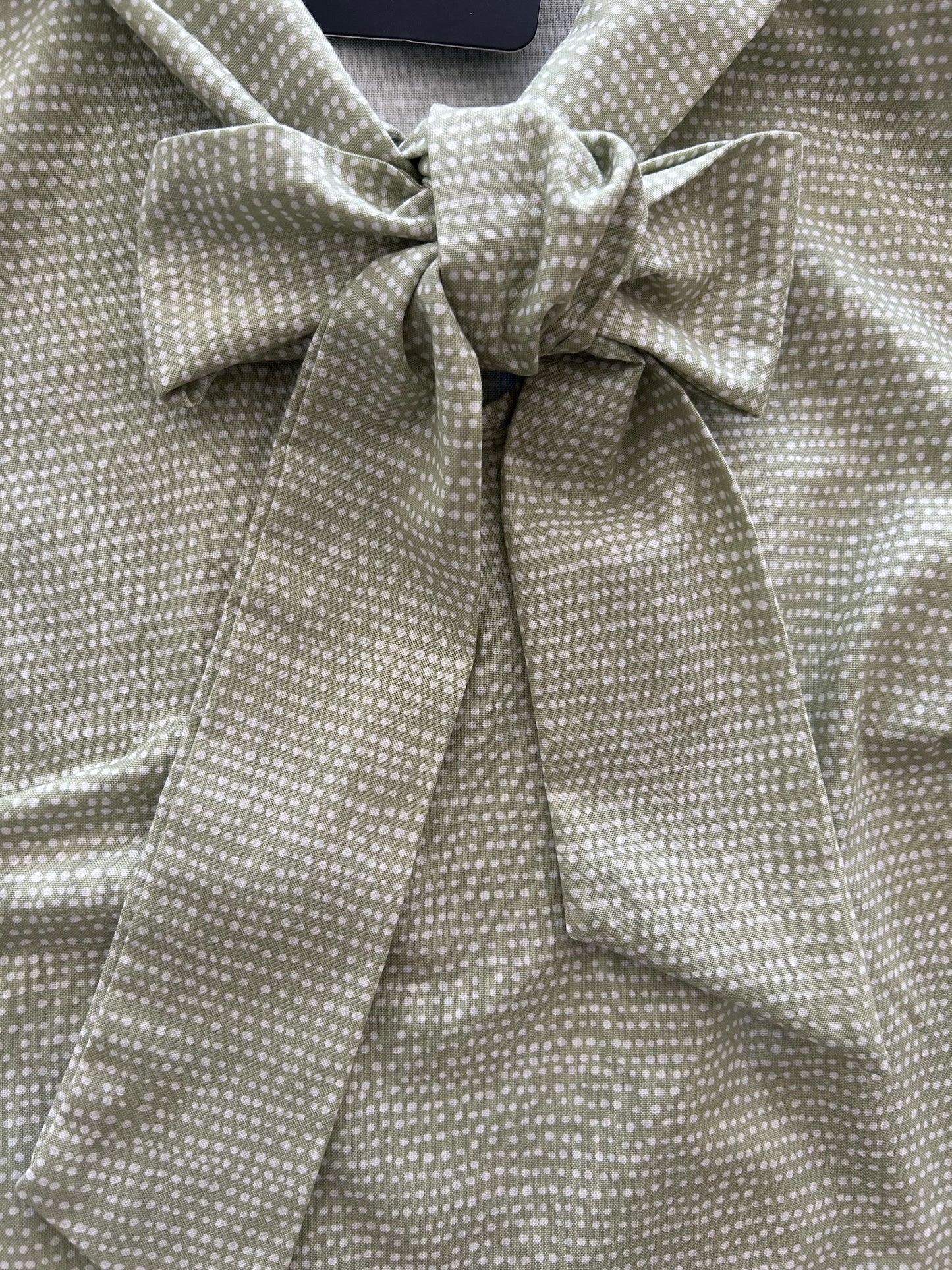 a close up of sage dot bow top showing the bow and dots