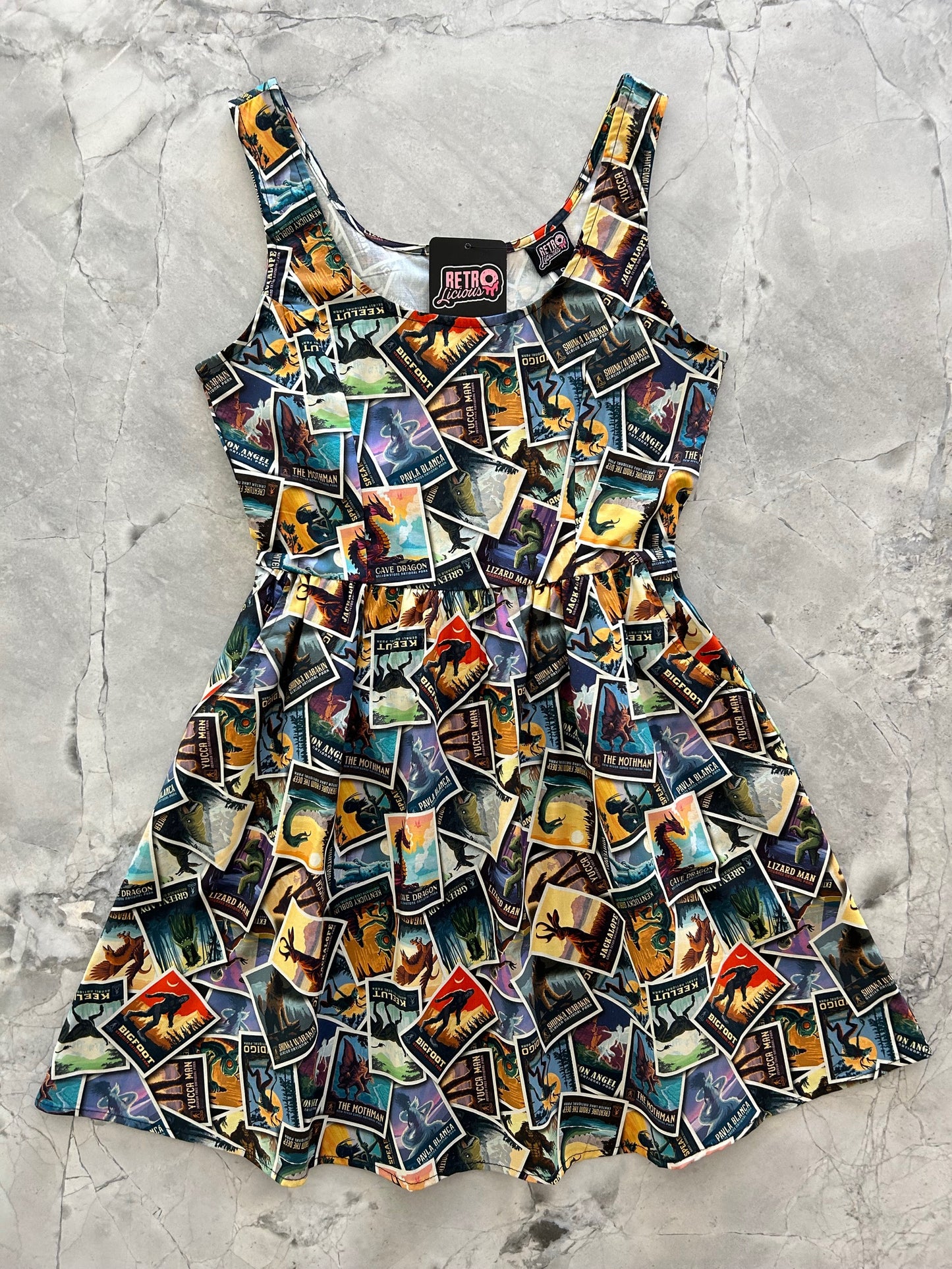 a flat lay of a dress showing tossed flyers of mythical creatures