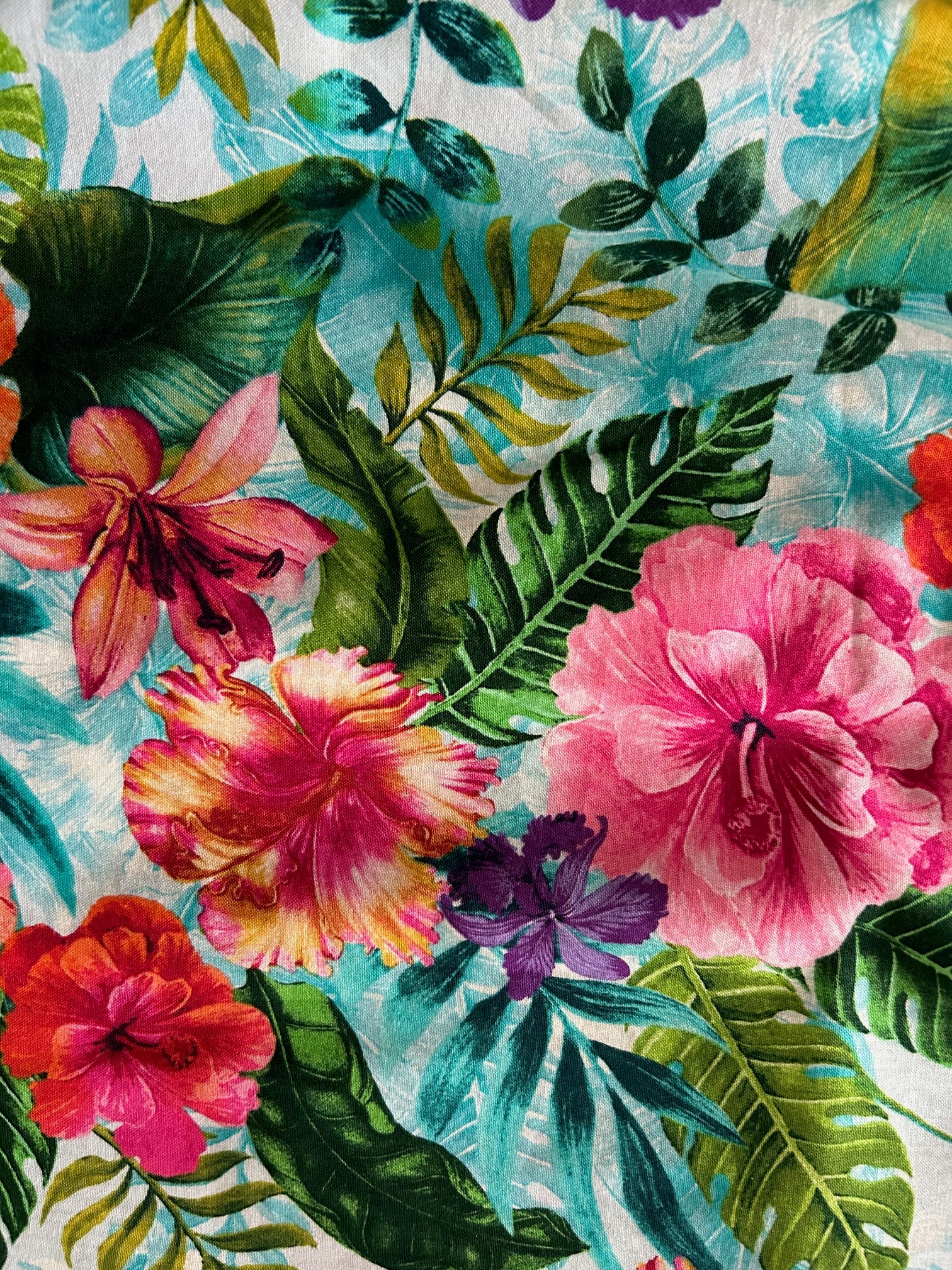 close up of fabric showing the colorful floral print on light blue background