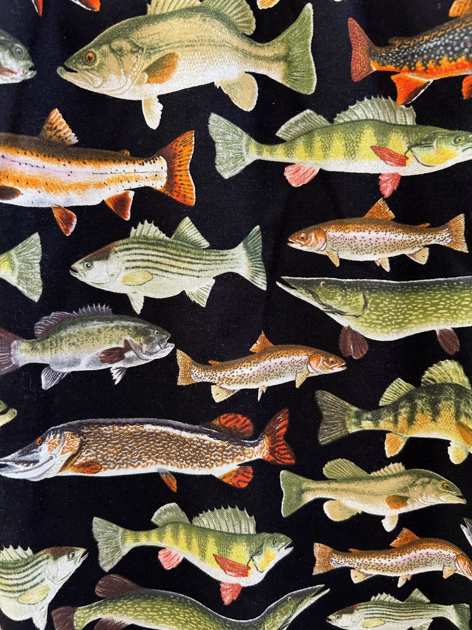a close up of the green fish on black background fabric