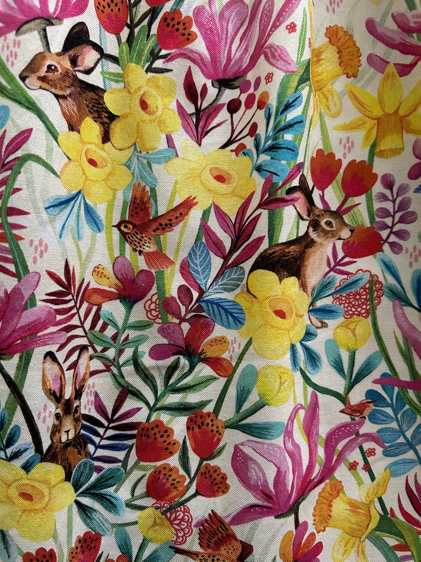close up showing the fabric print with bunnies, birds and flowers