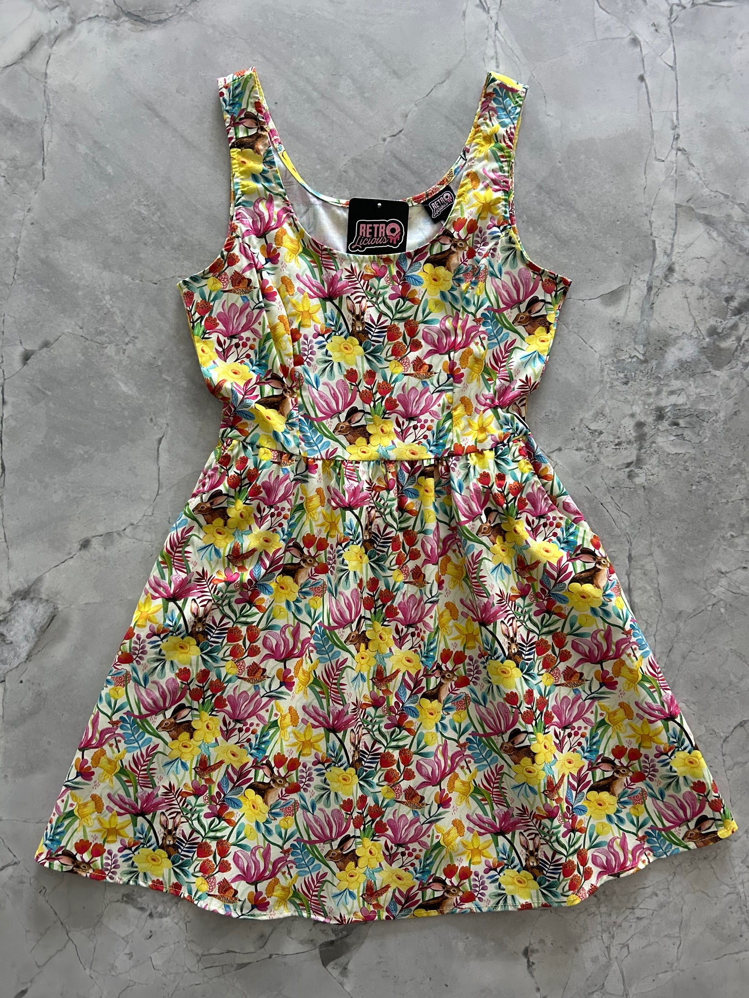 flatlay image of the front of the dress with yellow flowers and bunnies
