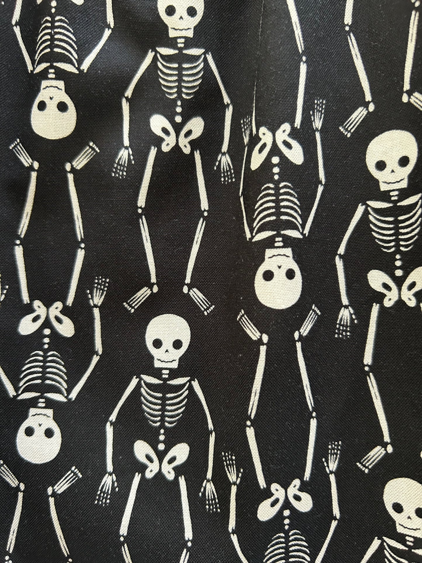 close up of fabric sowing the white skeletons on black bacground