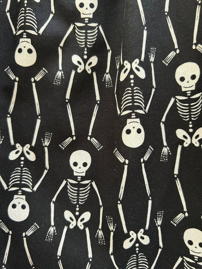close up of fabric sowing the white skeletons on black bacground