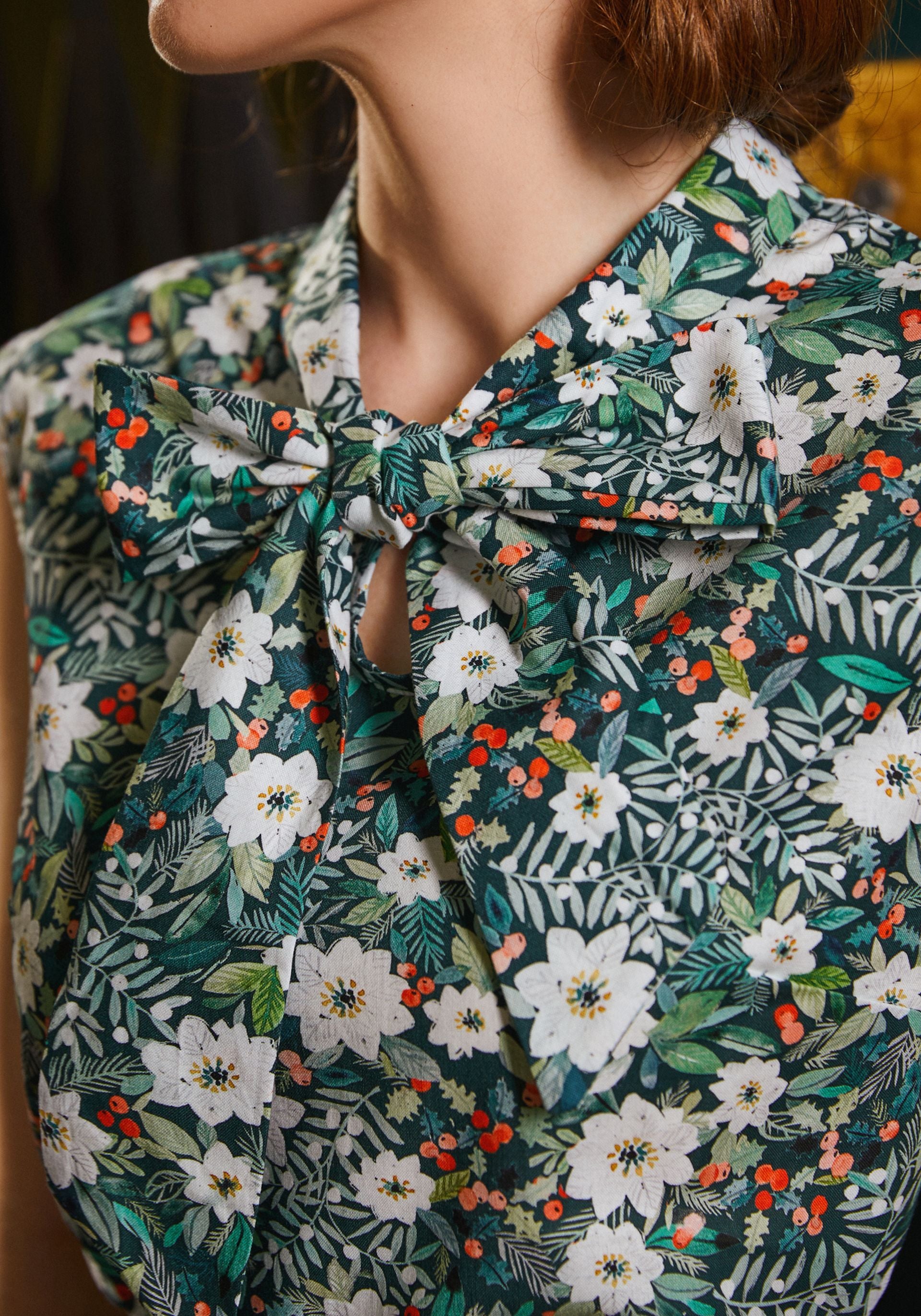 close up of the model wearing winter floral bow top