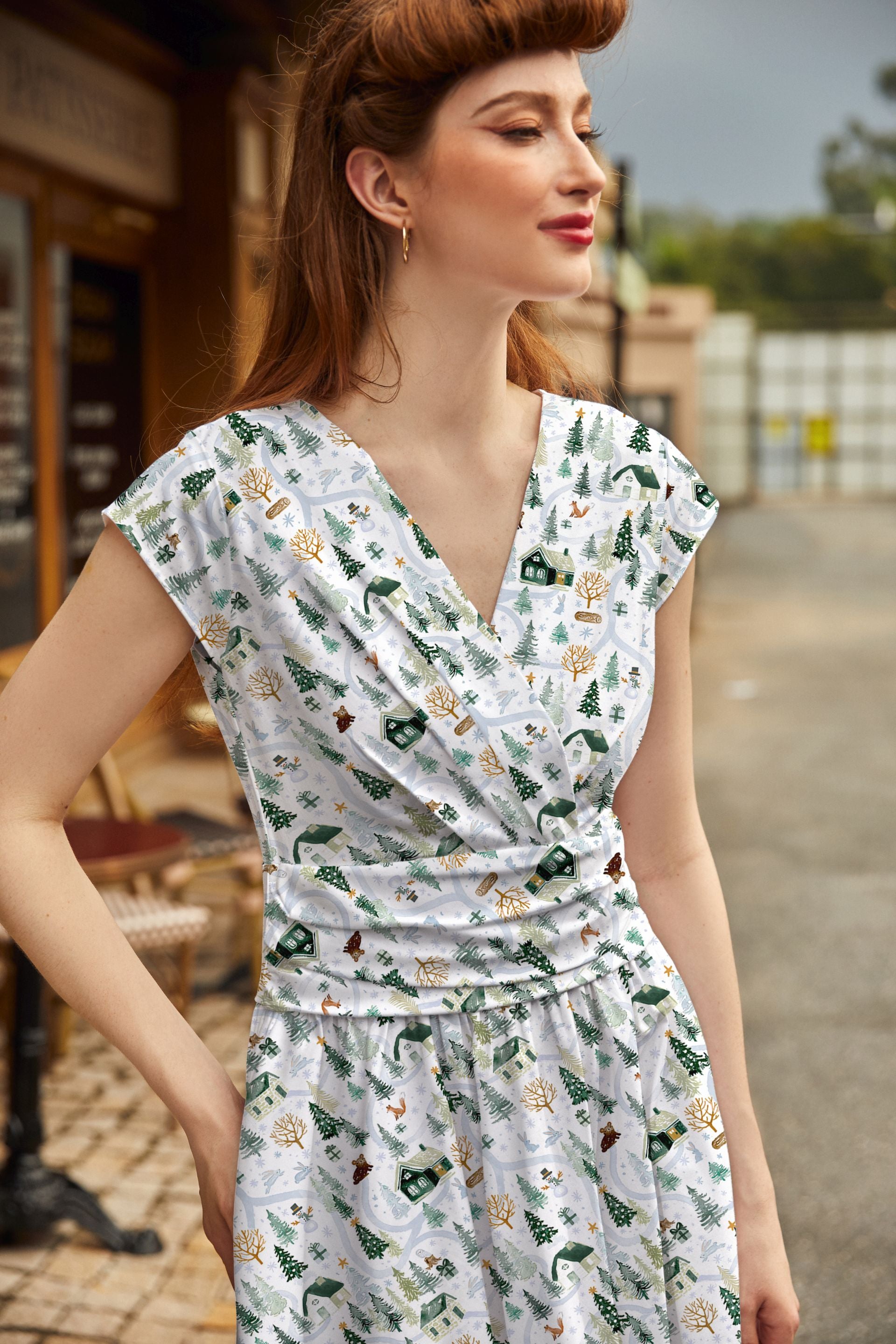 Woman wearing a floral dress standing outdoors.