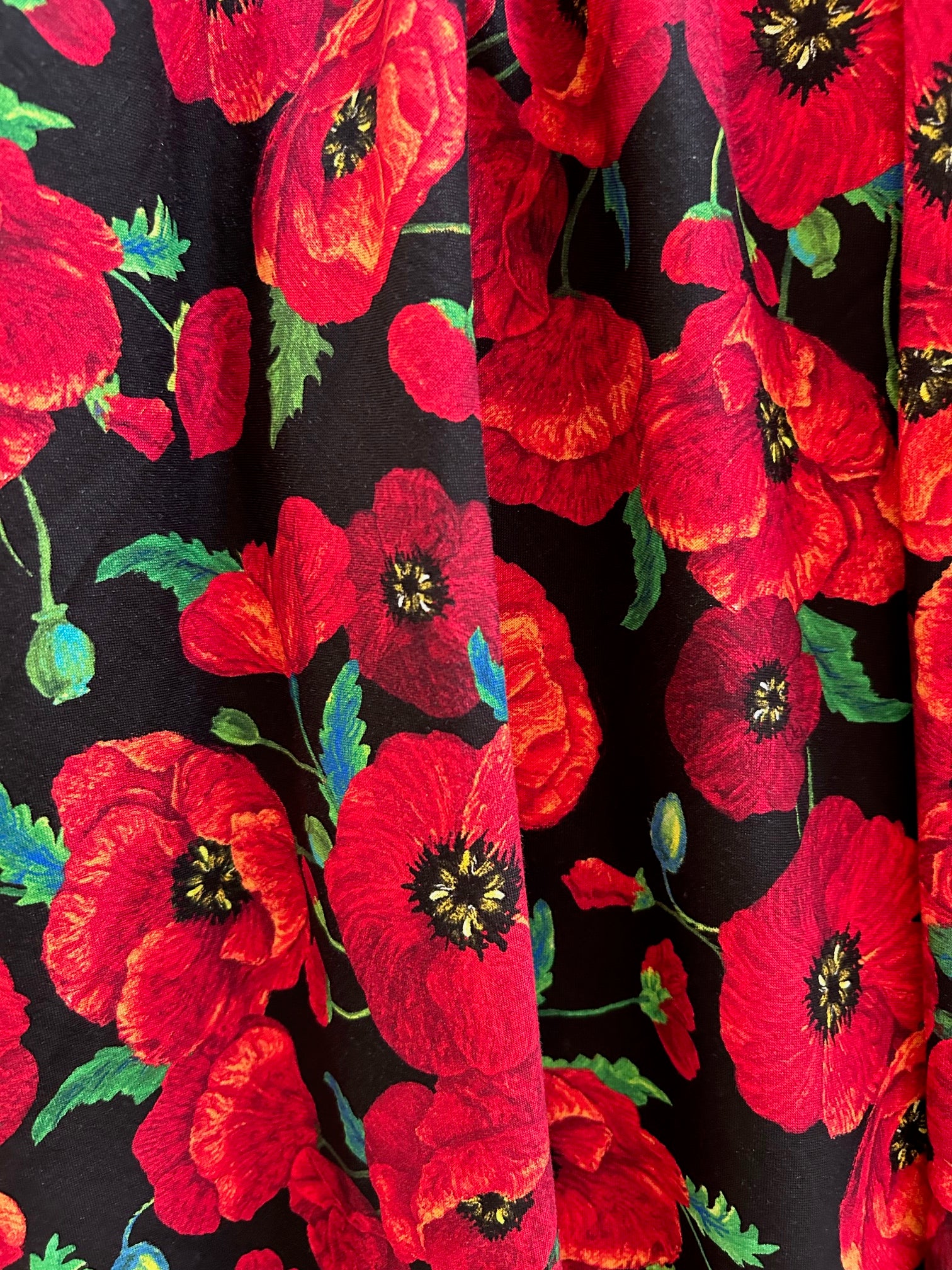 close up of floral poppy greta print showing the poppy print on black background