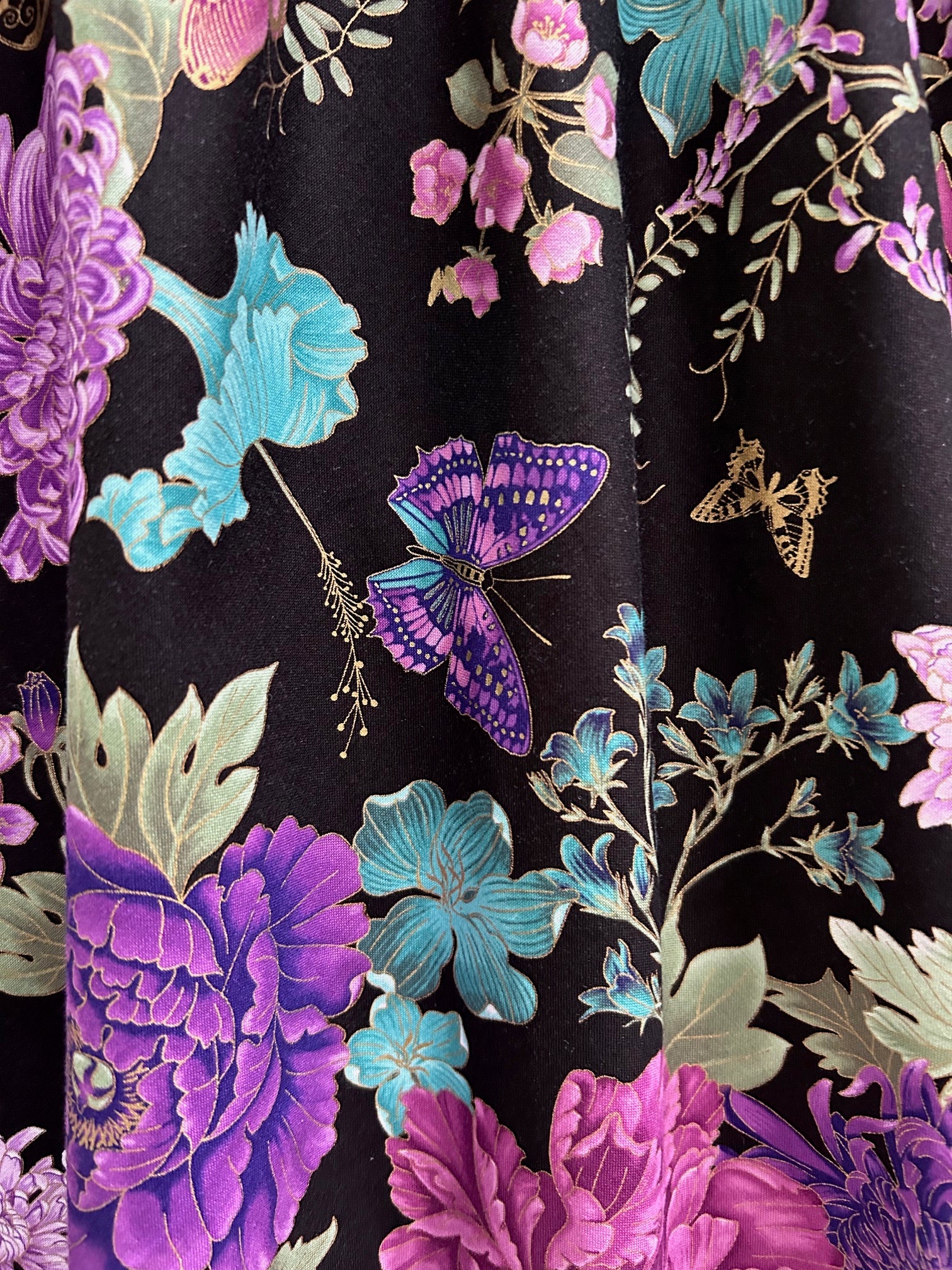 close up of print showing buttefly and flowers on black background