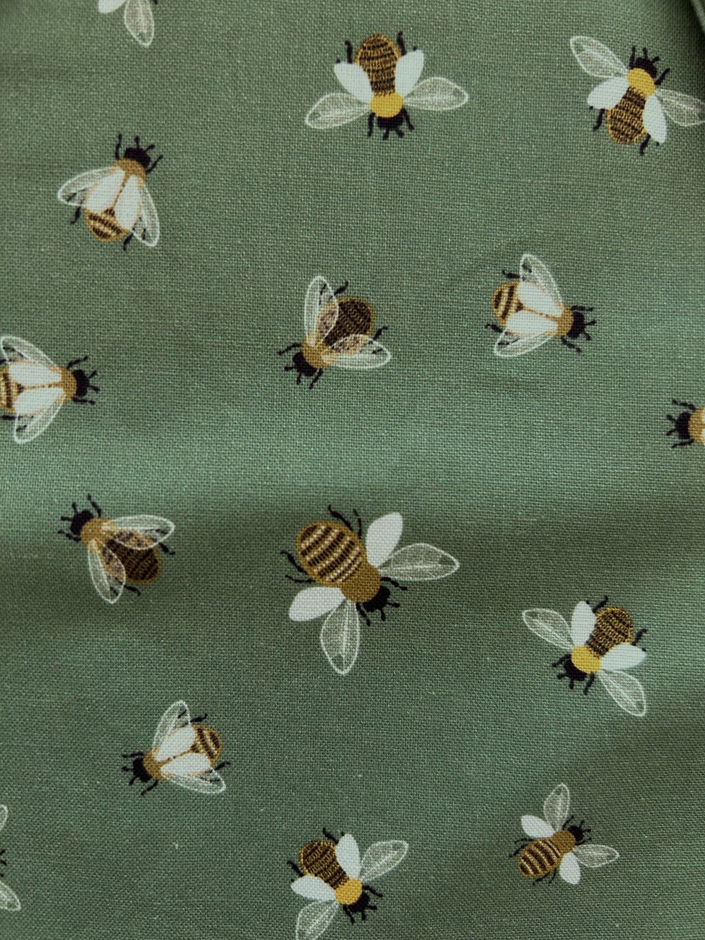 close up of bee print showing the all over bee print on green background