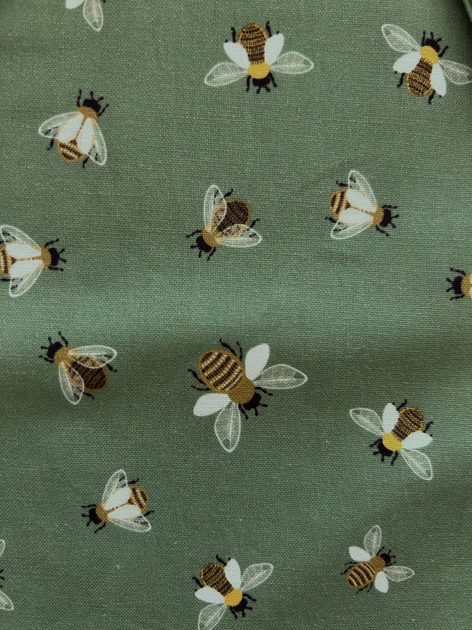close up of bee print showing the all over bee print on green background