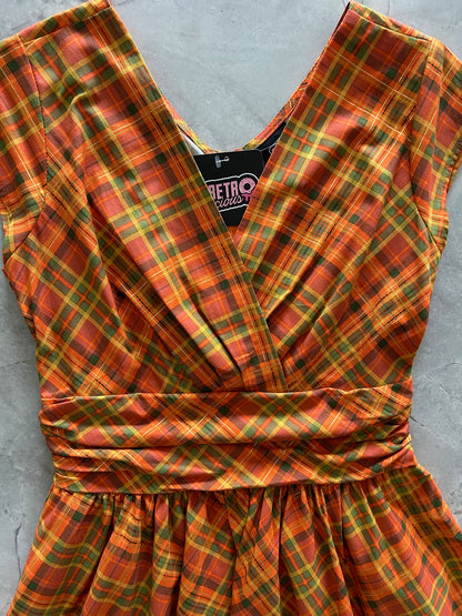 Plaid fabric with orange and green pattern on a gray surface