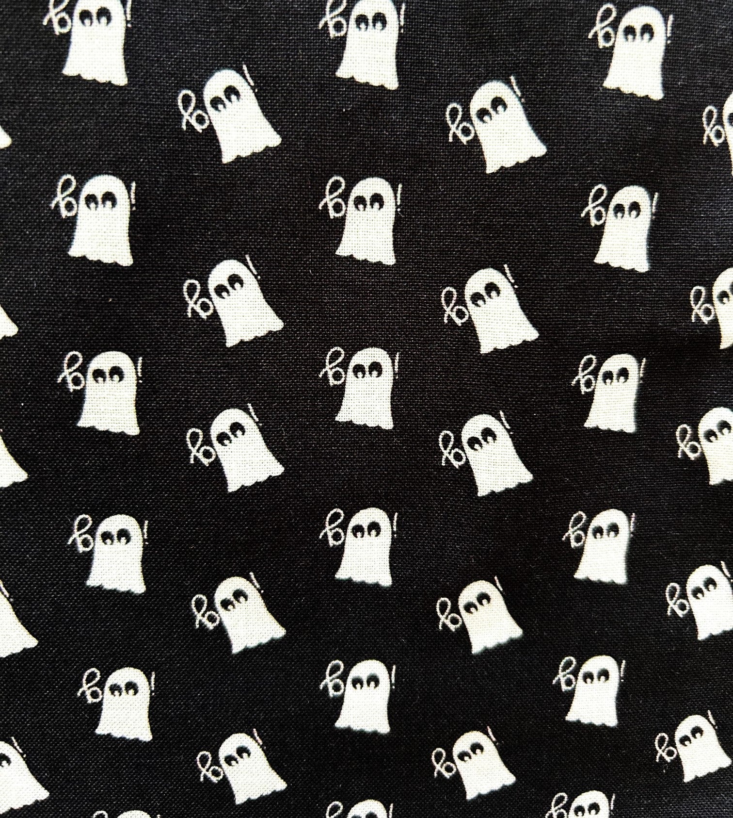 close up of mini ghosts print on black background and white ghosts