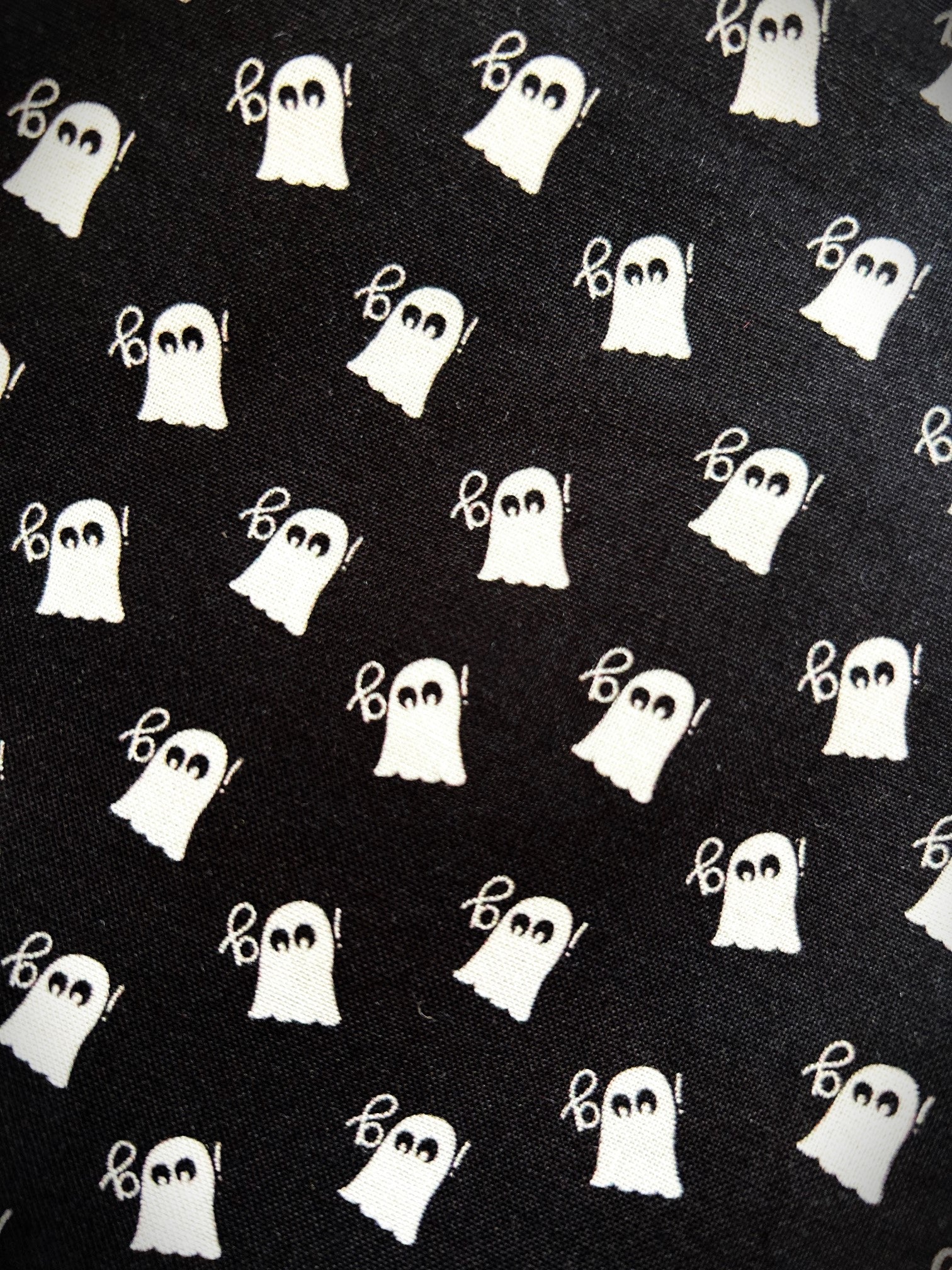 close up of mini ghosts print on black background