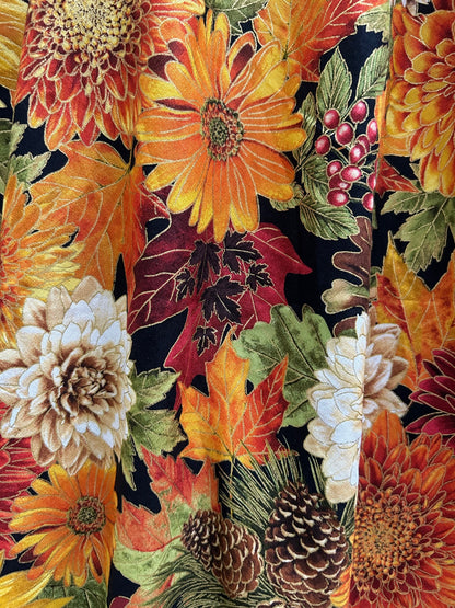 Colorful fabric with autumn-themed pattern featuring flowers, leaves, and berries.