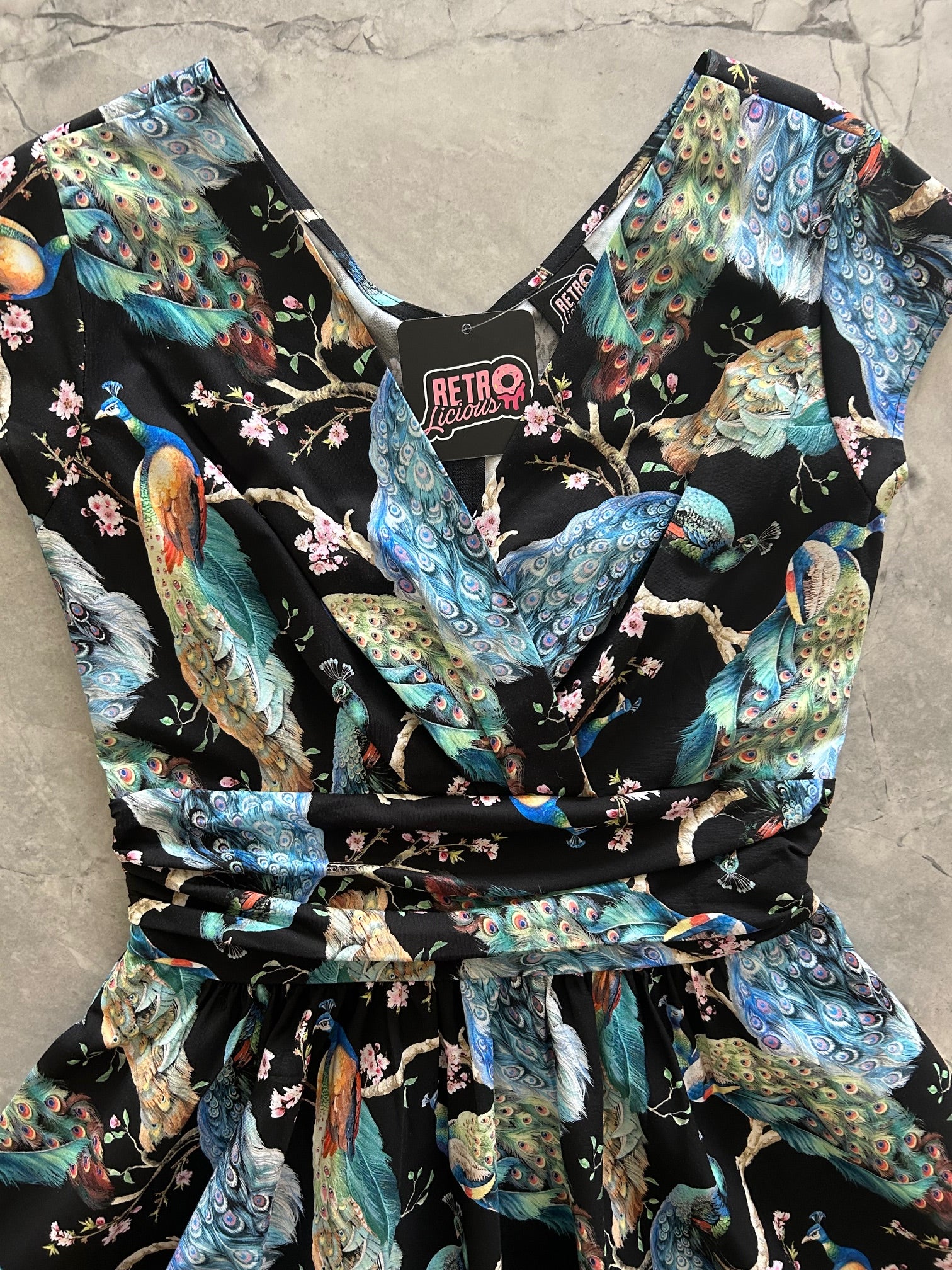 flatlay of  the bodice of our peacock on branches greta dress