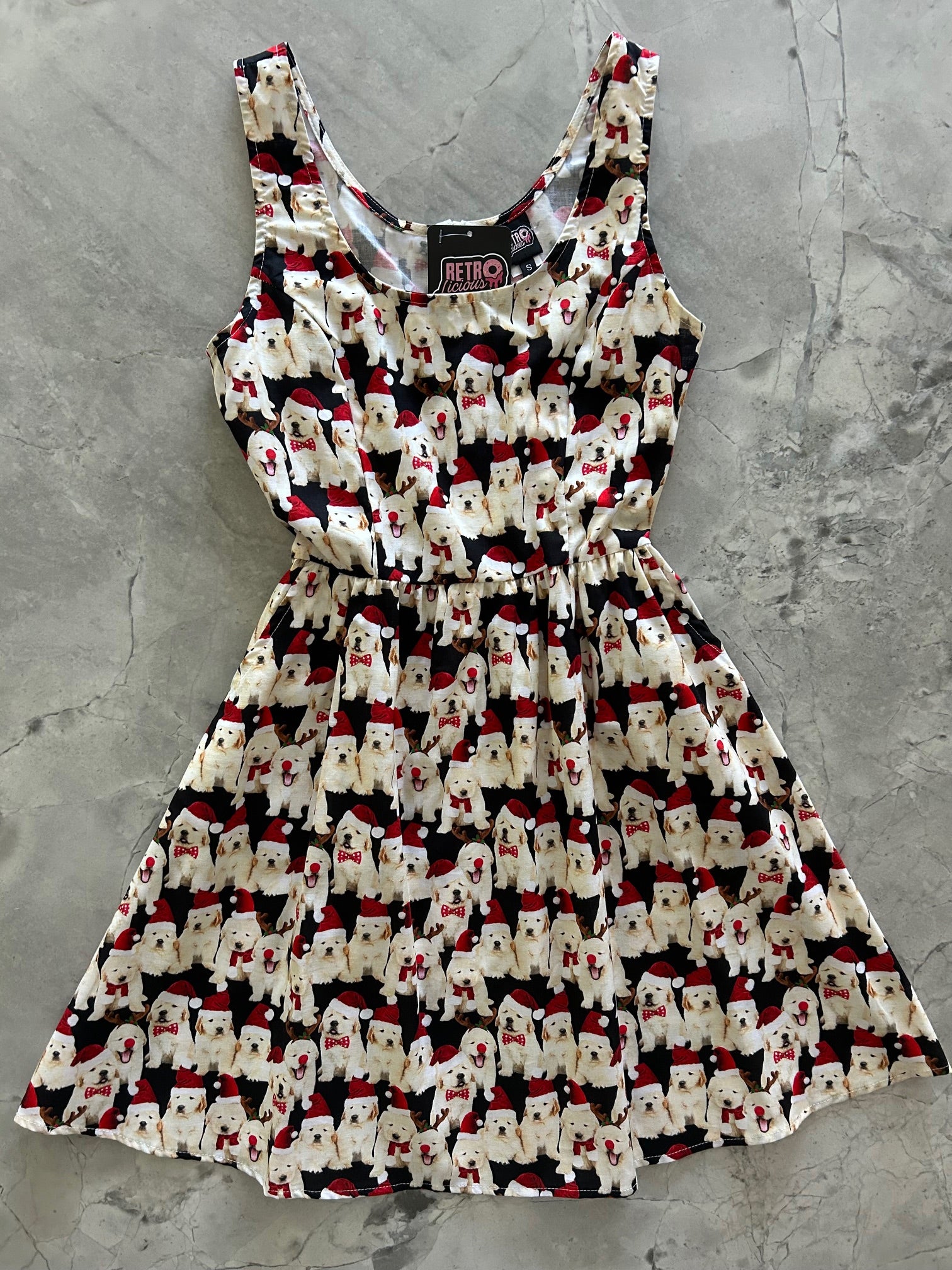 flatlay of dogs in santa hats on black background