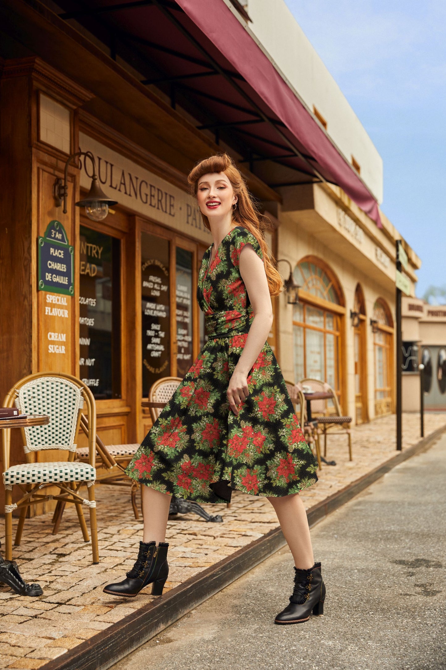 model wearing poinsetiia greta dress stepping on a sidewalk