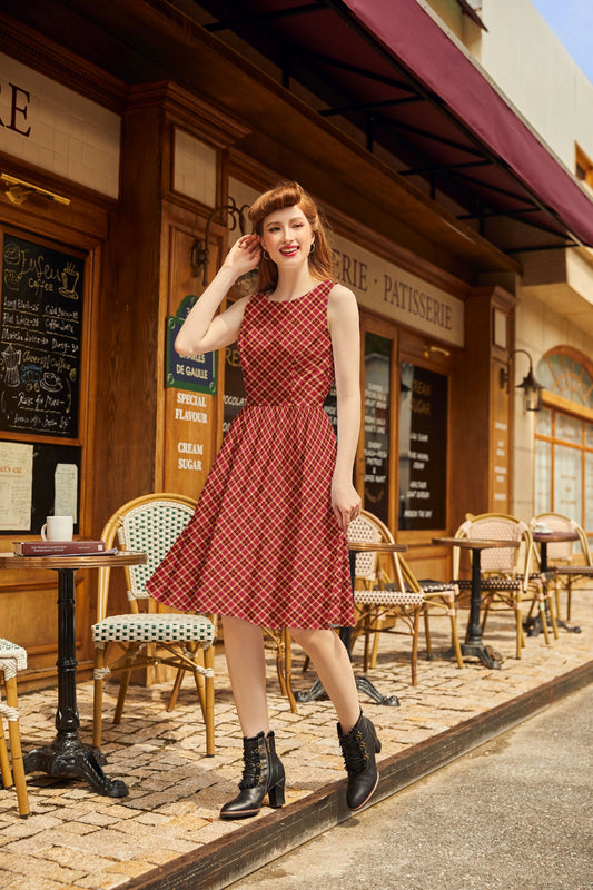 model wearing our holiday plaid dress walking on a sidewalk near a cafe