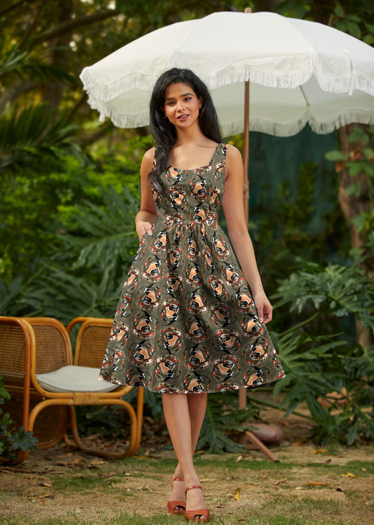 Woman in a floral dress holding a white umbrella in a garden setting