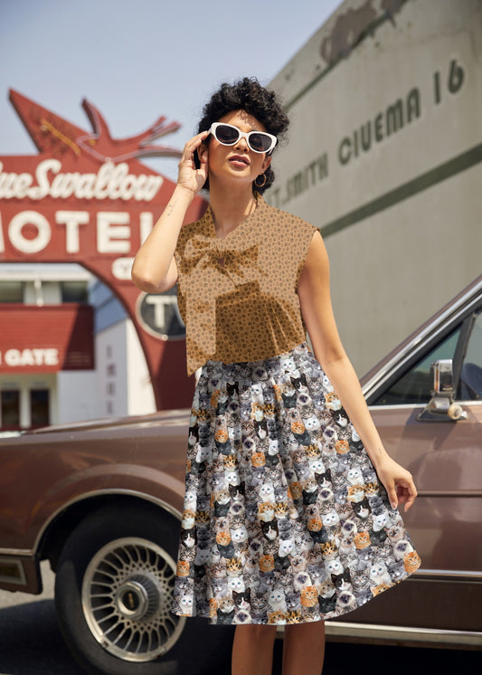 Woman in a patterned dress standing in front of a vintage car with a motel sign in the background