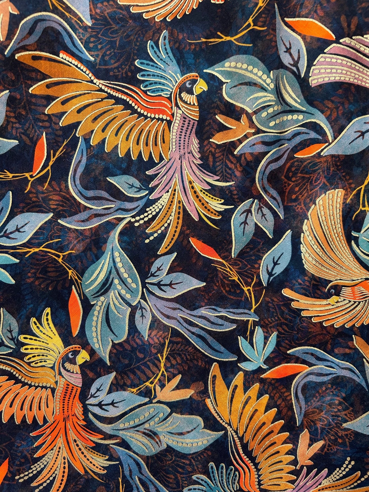 close up of the print showing birds and leaes and metallic details