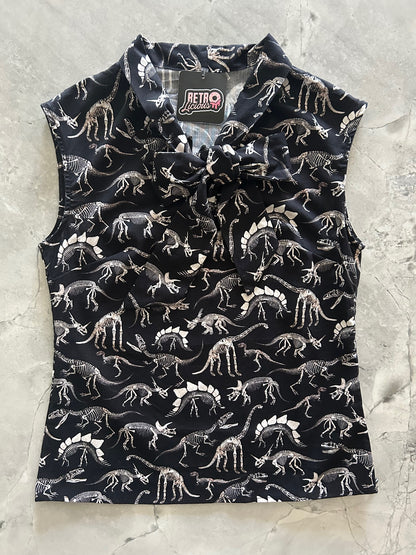 Black bow top with white dinosaur pattern on a light gray surface