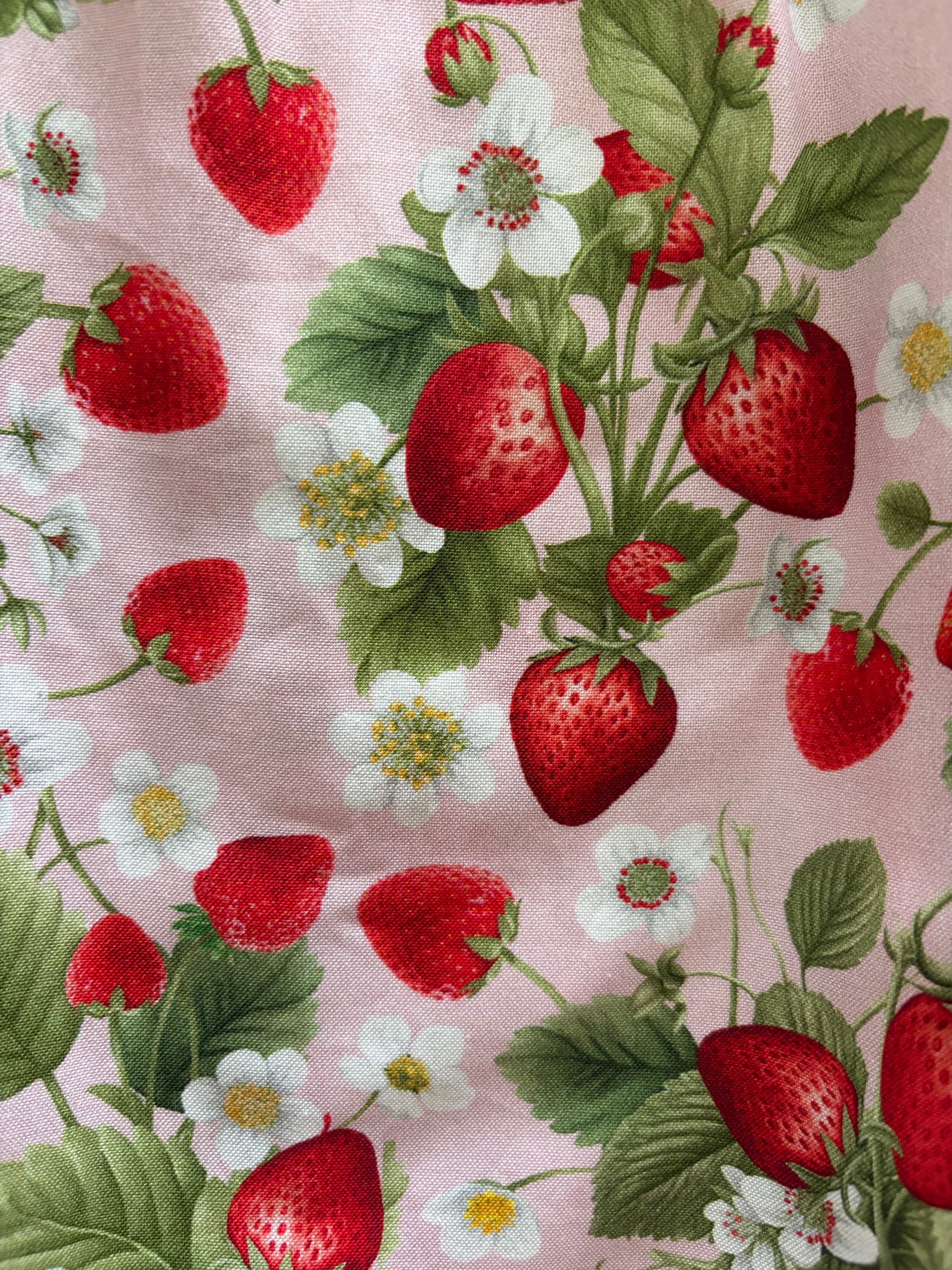 Fabric with strawberry pattern on a pink background