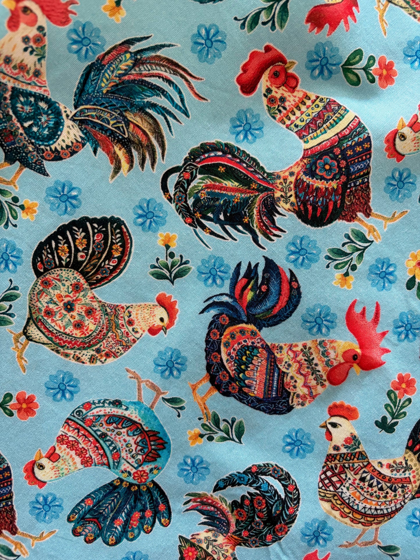 Colorful pattern of roosters and flowers on a blue background
