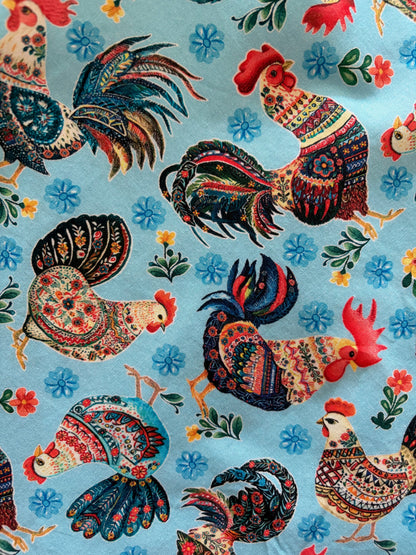 Colorful pattern of roosters and flowers on a blue background