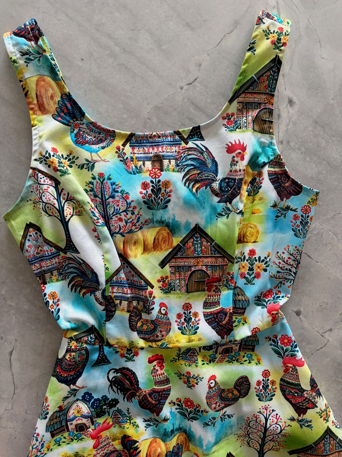 Colorful fabric with rooster pattern on a gray surface