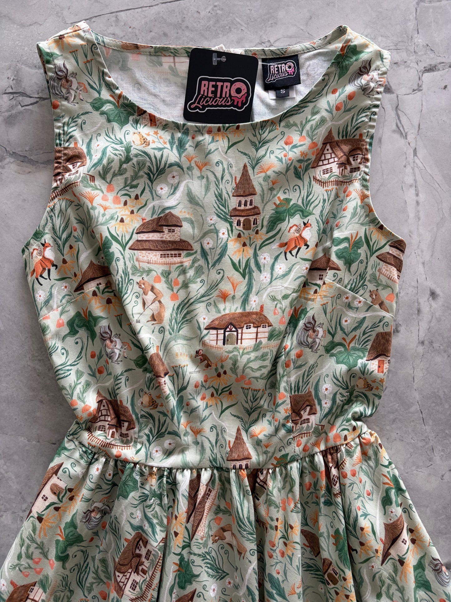 Floral dress with a pattern of houses and animals on a gray surface