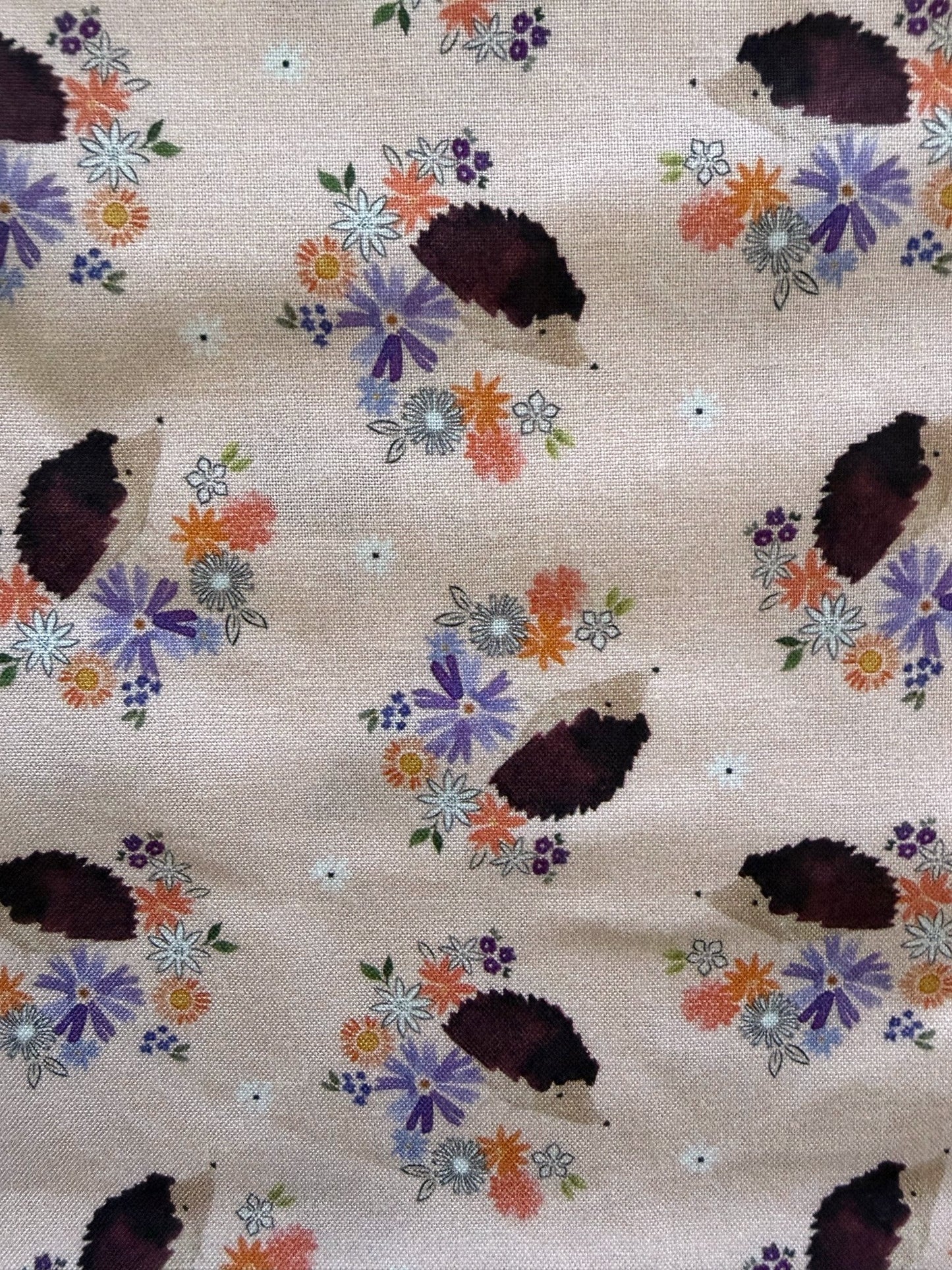 Fabric with hedgehog and floral pattern on a beige background