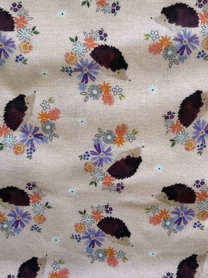 Fabric with hedgehog and floral pattern on a beige background