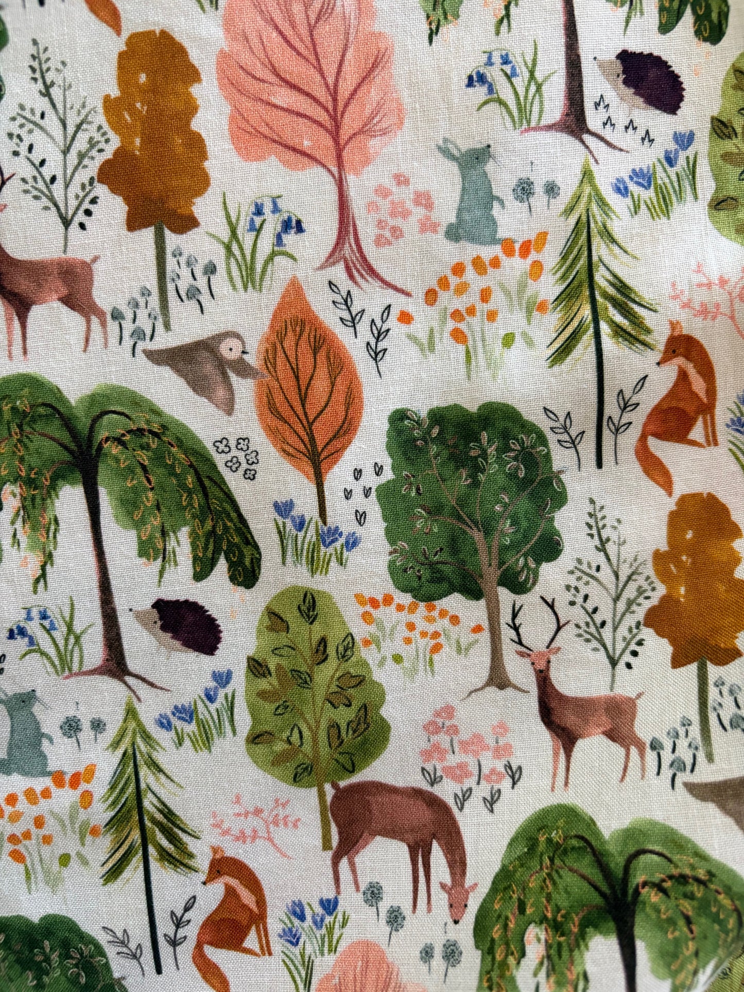 Patterned fabric with forest animals and plants on a white background