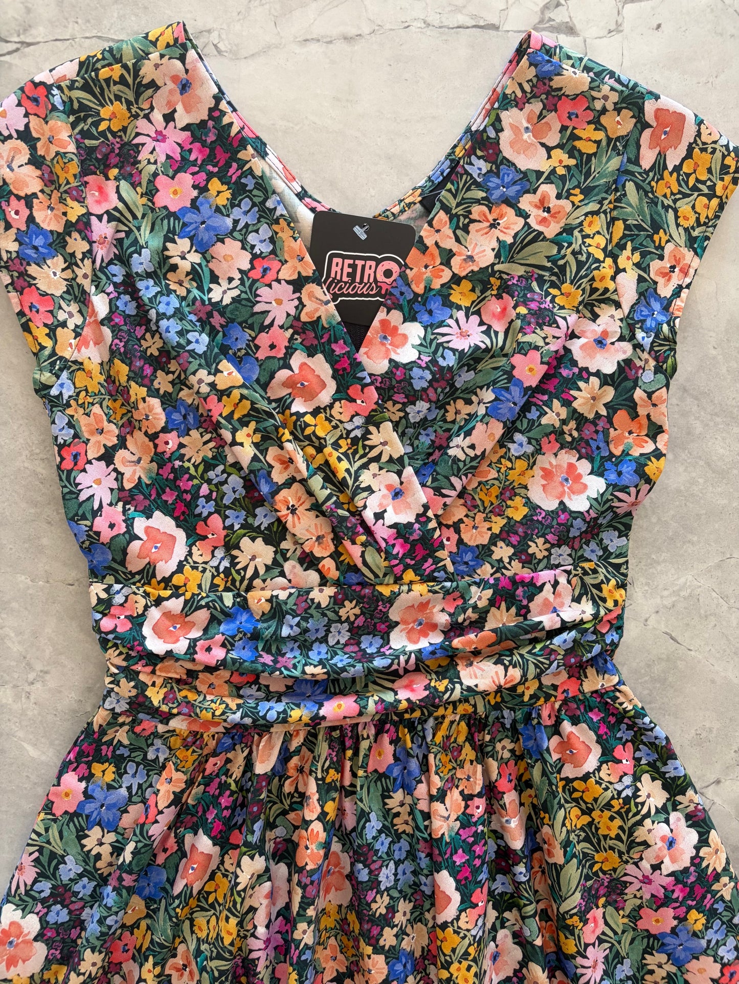 Floral dress with a 'Retro' label on a concrete surface