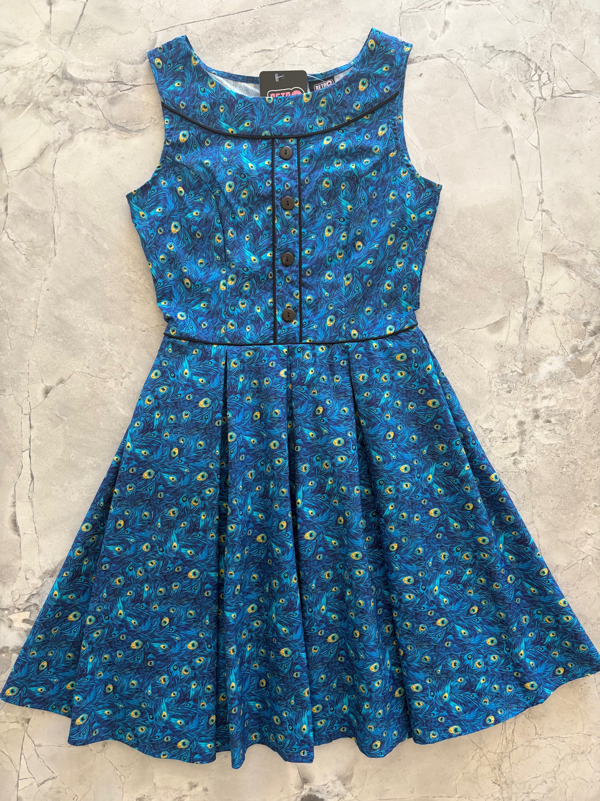 Blue peacock patterned dress on a textured surface