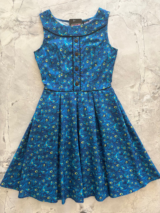 Blue peacock patterned dress on a textured surface