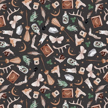 a close up of the fabric swatch showing the print with tossed toads, moths, candles books, broomsticks and snails