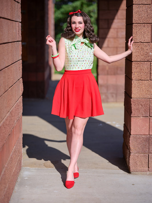 a model standing outdoors wearing the tomato skater skirt