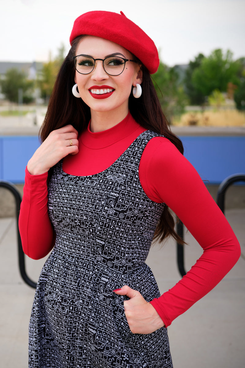 Close up of model wearing a red mock turtleneck underneath a dress