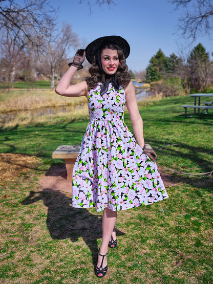 a model in a park wearing magnolia midi dress and a black vintage hat
