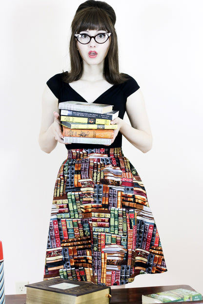 a full size image of a model wearing our Don't Judge a Book by its Cover Skirt and holding books
