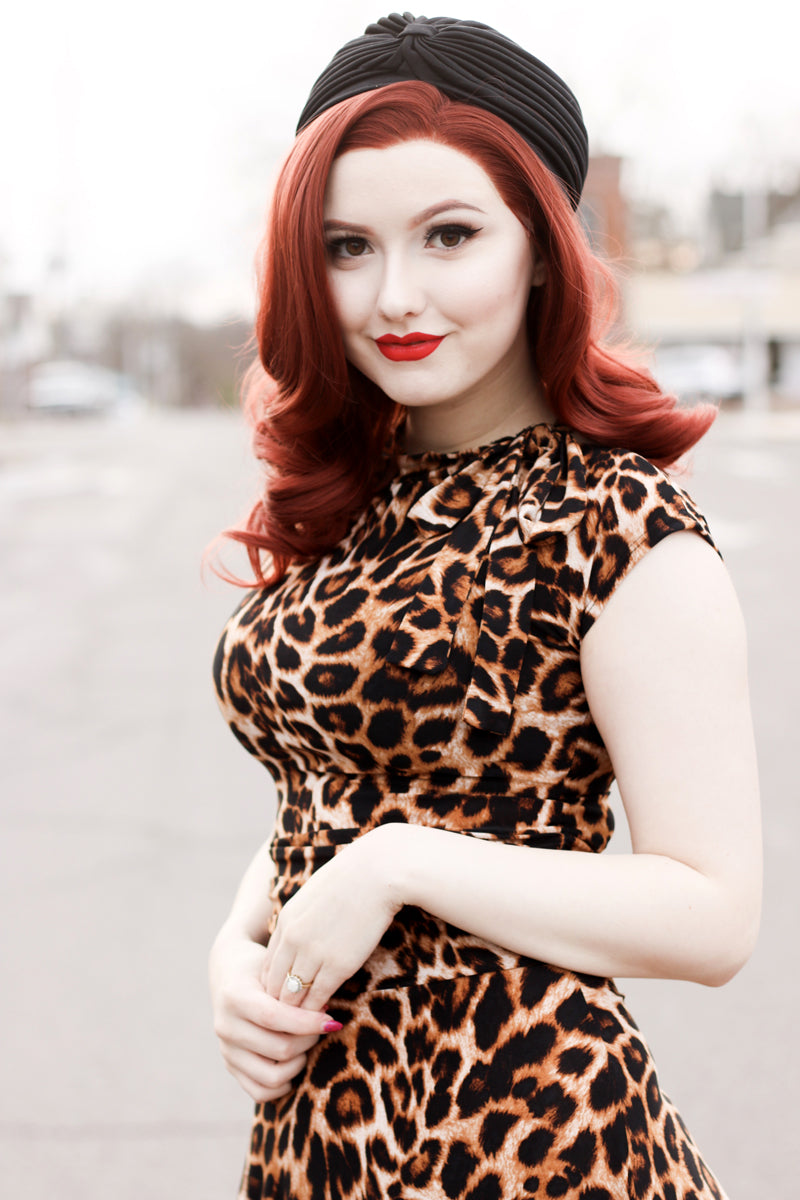 a close up of a model wearing our Leopard Bombshell dress