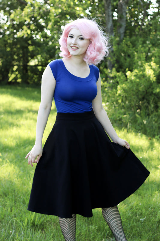 a full length of a model standing in front of trees wearing our boat neck to in royal blue