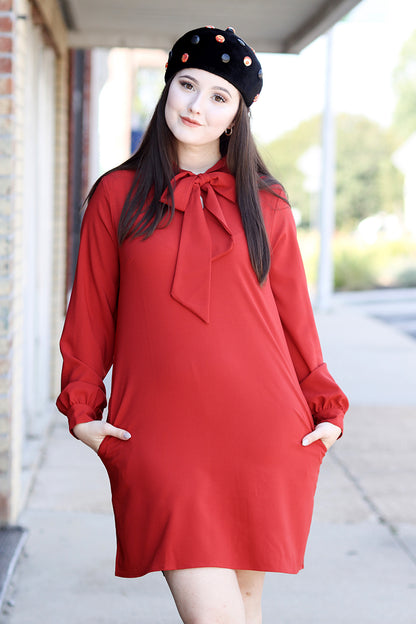 Female model wearing red mod style dress with black beret.
