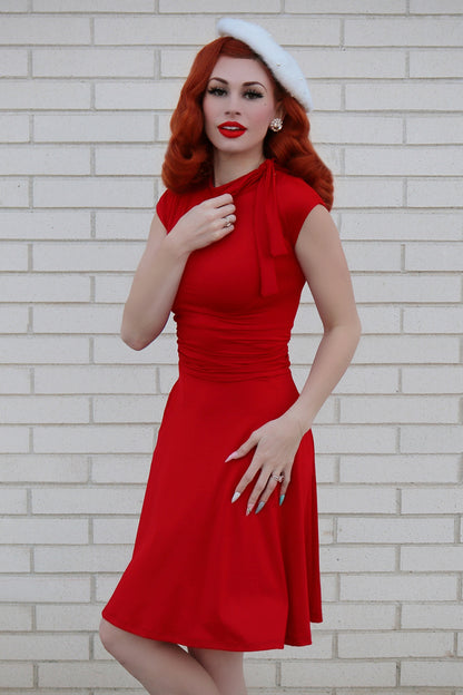 Model wearing red vintage dress and white beret. 