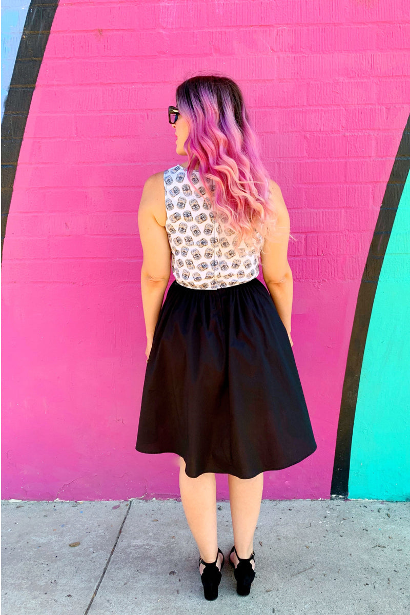 back side of a model in front of a pink wall wearing the hedgehog twofer dress