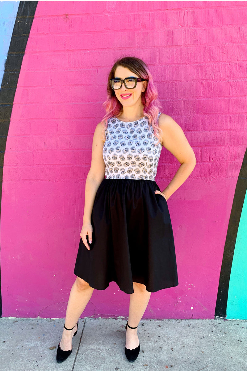 a full size image of a model standing in front of pink wall with her hand in her pocket wearing the hedghog twofer dress
