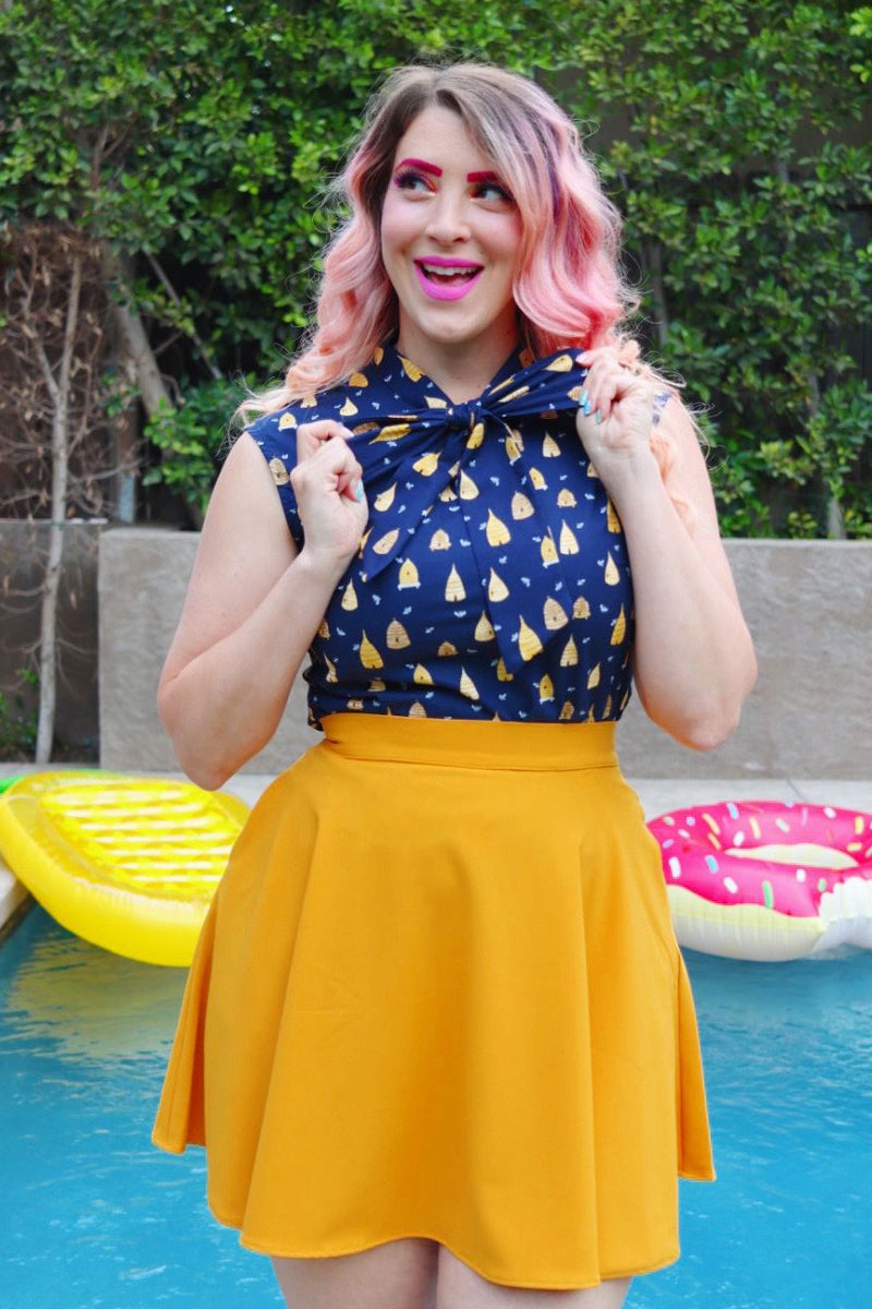 model standing in front of a pool wearing our beehive bow top